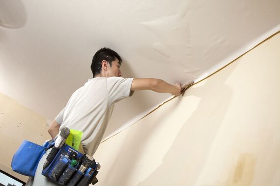 クロスの貼り換え作業を行うスタッフ